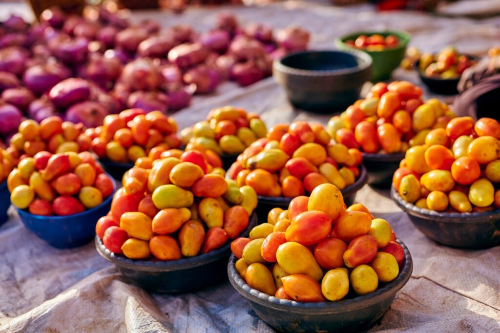 Vibrant display of fresh tomatoes and onions at an outdoor market.